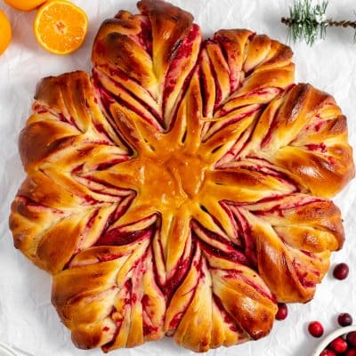 golden baked cranberry star bread on white background