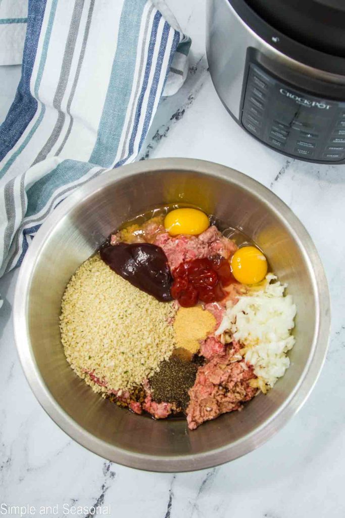 metal mixing bowl full of all meatloaf ingredients