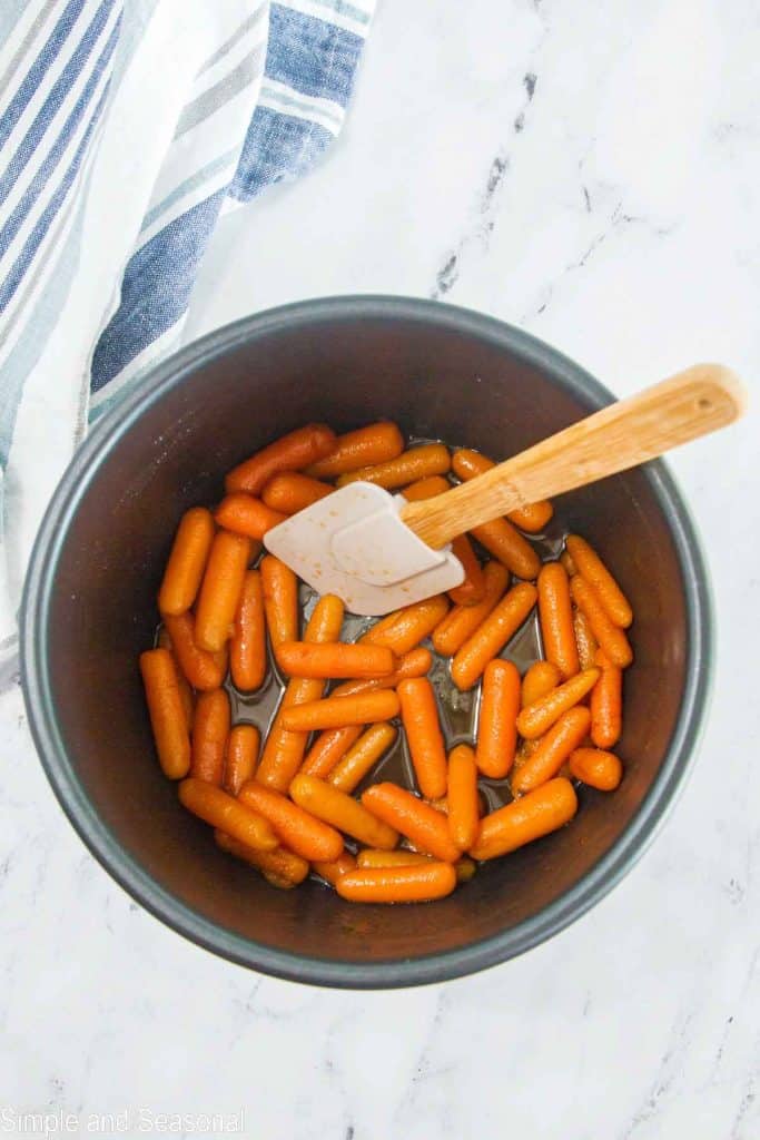 cooked carrots in the bottom of the pot with melted butter and sugar