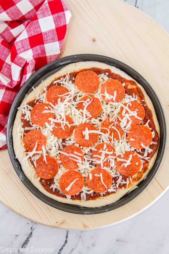 uncooked pizza with dough, sauce, cheese and pepperoni