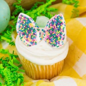 square image of single cupcake with marshmallow ears decorated with colorful sprinkles and small candy tail