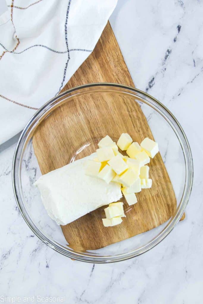 butter cubes and block of cream cheese in a mixing bowl