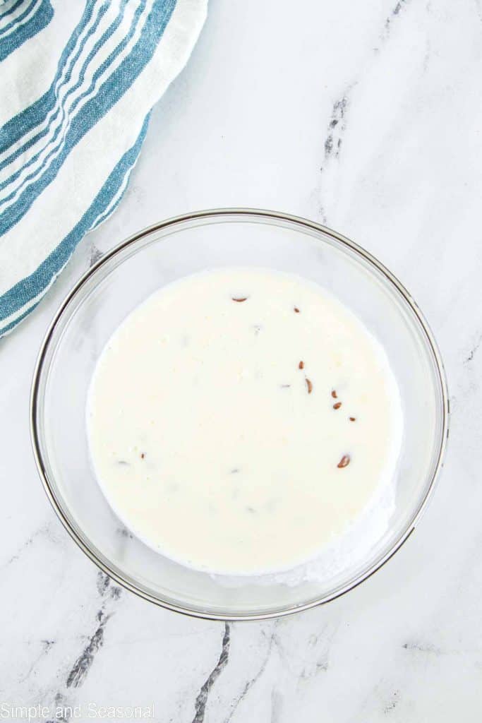 heavy cream and chocolate chip sitting in glass bowl unstirred