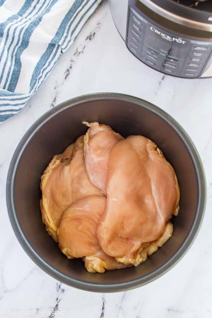 large chicken breasts inside the inner pot of a Crockpot Express