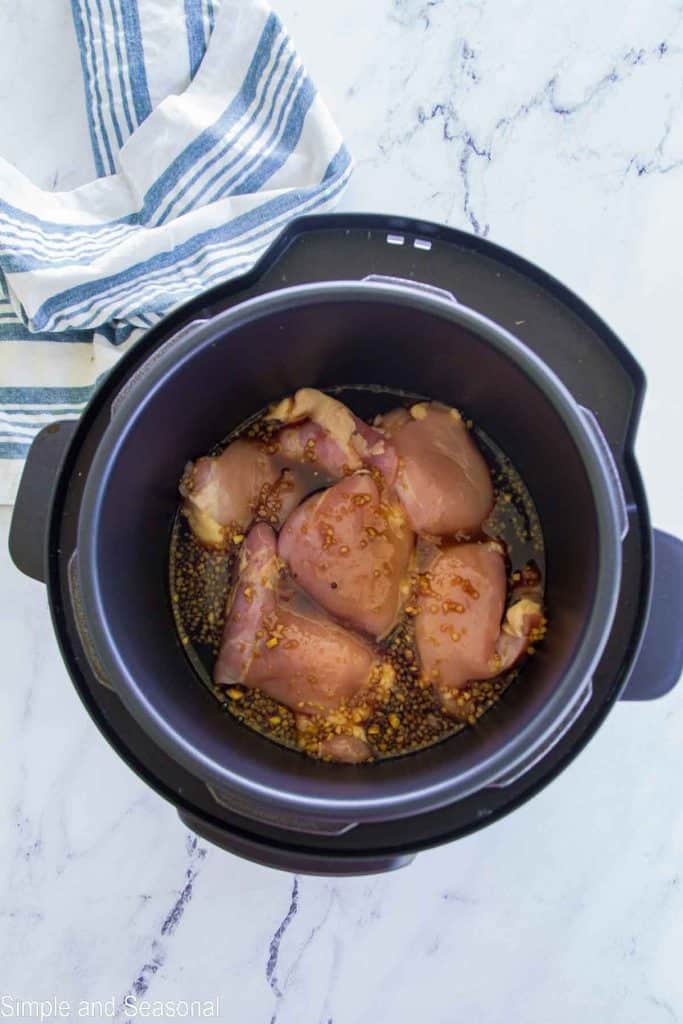 raw chicken with sauce in the cooking pot