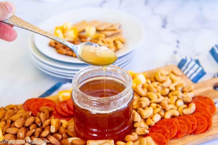 spoonful of hot honey drizzling into the jar
