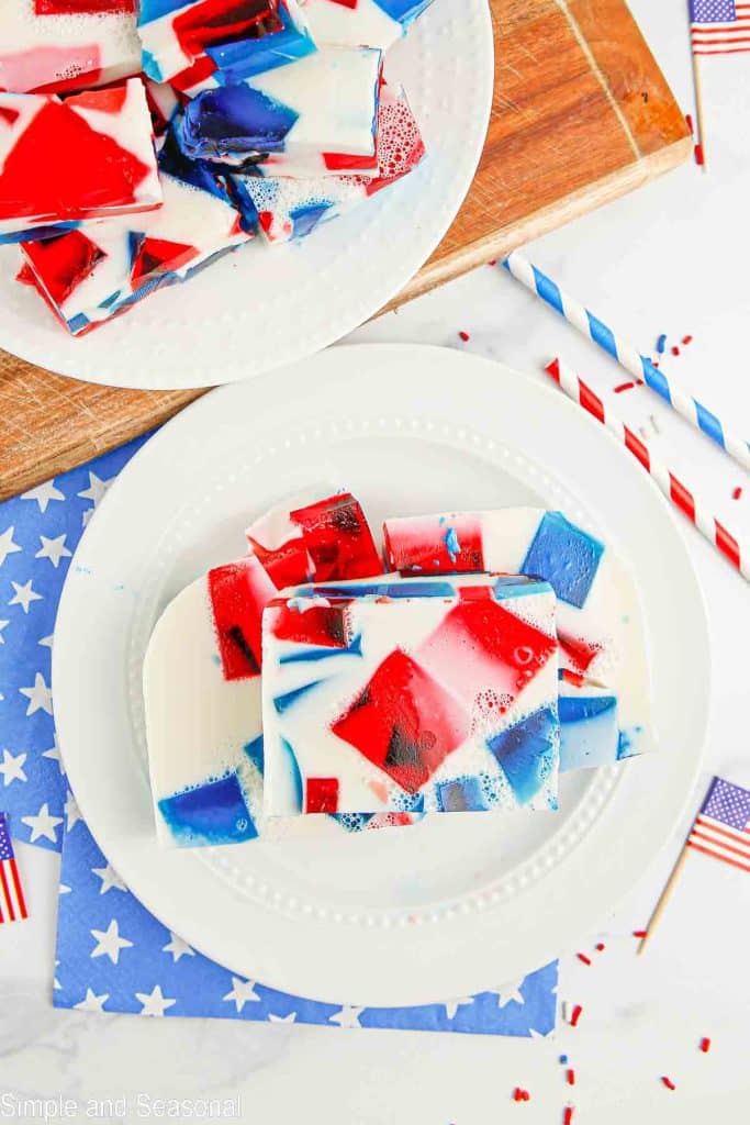 top down view of slices on patriotic broken glass jello on a plate with red and white striped decor