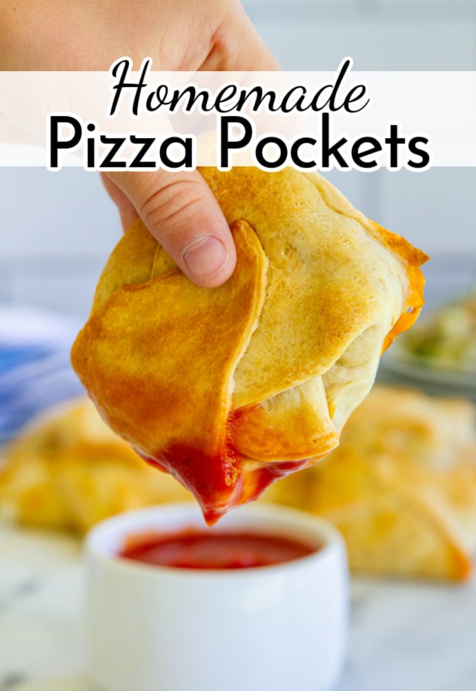 hand holding a pizza pocket dipping into marinara sauce; text label reads: Homemade Pizza Pockets