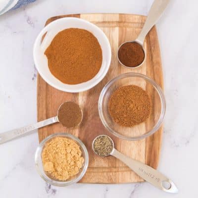 spices in bowls on a wooden cutting board;