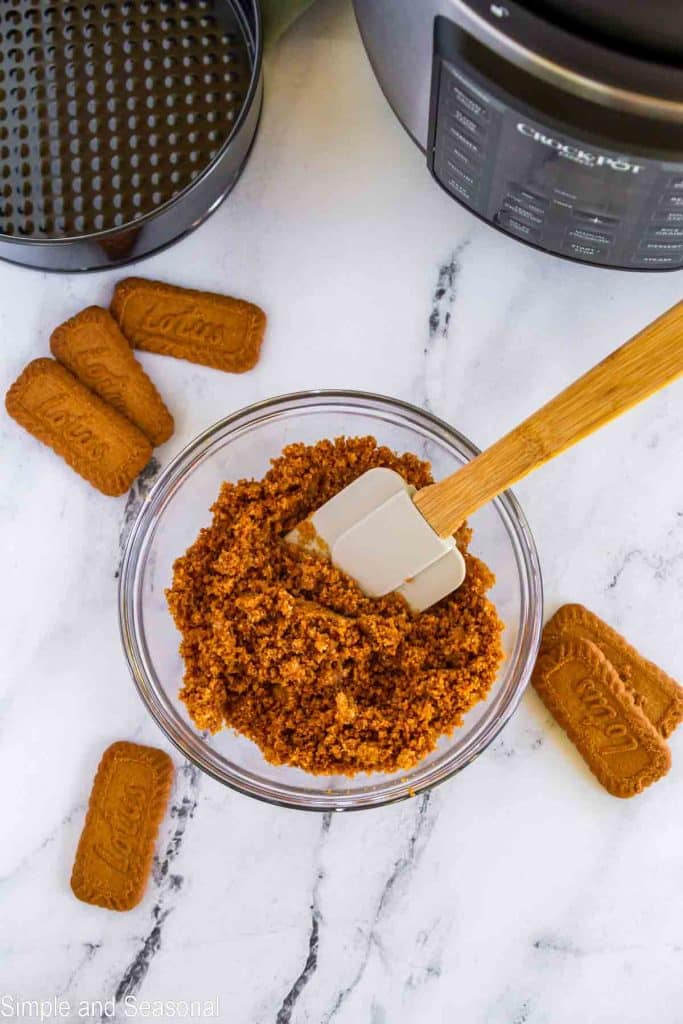 bowl with mixed butter, sugar and cookie crumbs and spatula