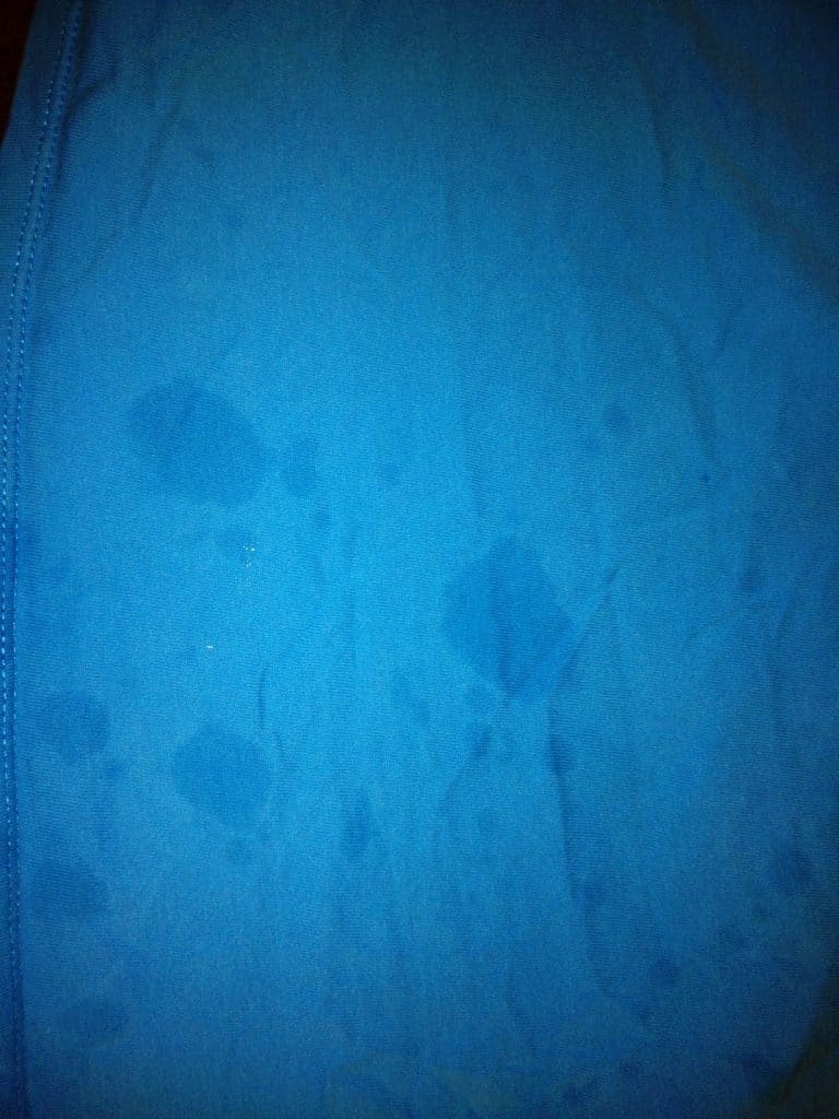 blue shirt with grease spots all over it