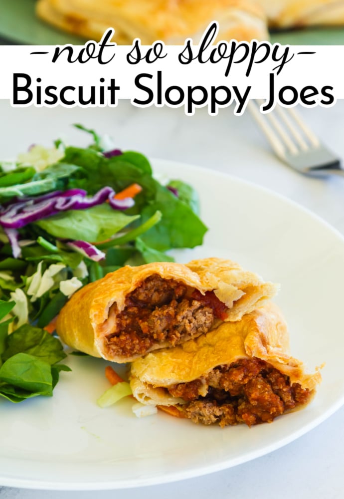 cut open sloppy joe in a biscuit on a white plate with platter of more cooked biscuits in the background; text label reads: not so sloppy biscuit sloppy joes