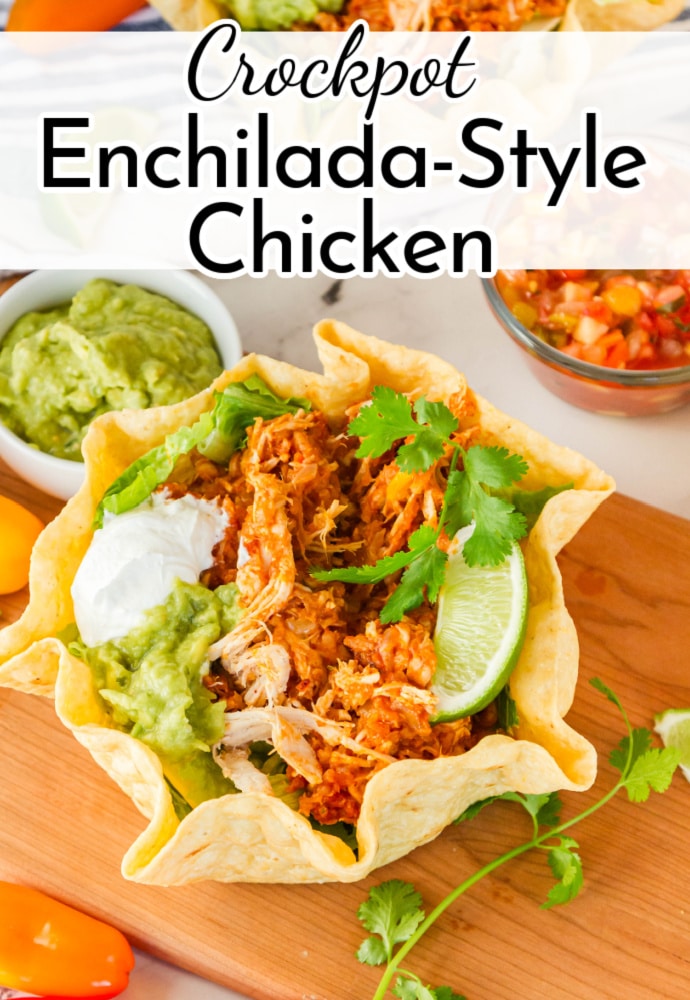 crunchy taco salad bowl filled with shredded chicken and topped with lime wedge, cilantro and sour cream; text reads: Crockpot Enchilada Style Chicken