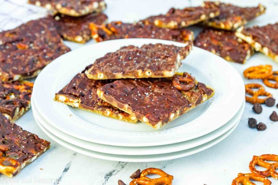 salted squares of pretzel bark stacked on a white plate