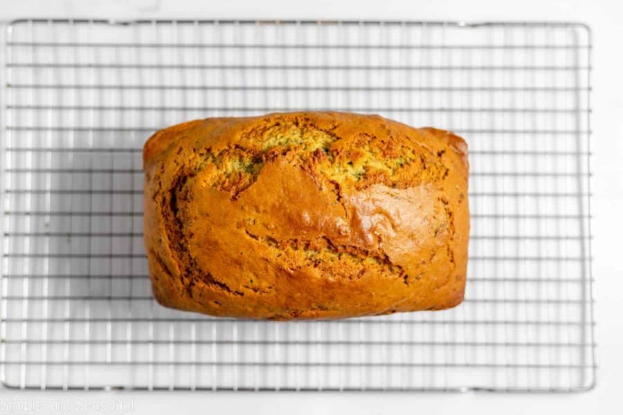 baked loaf of lemon zucchini bread cooling on a wire rack