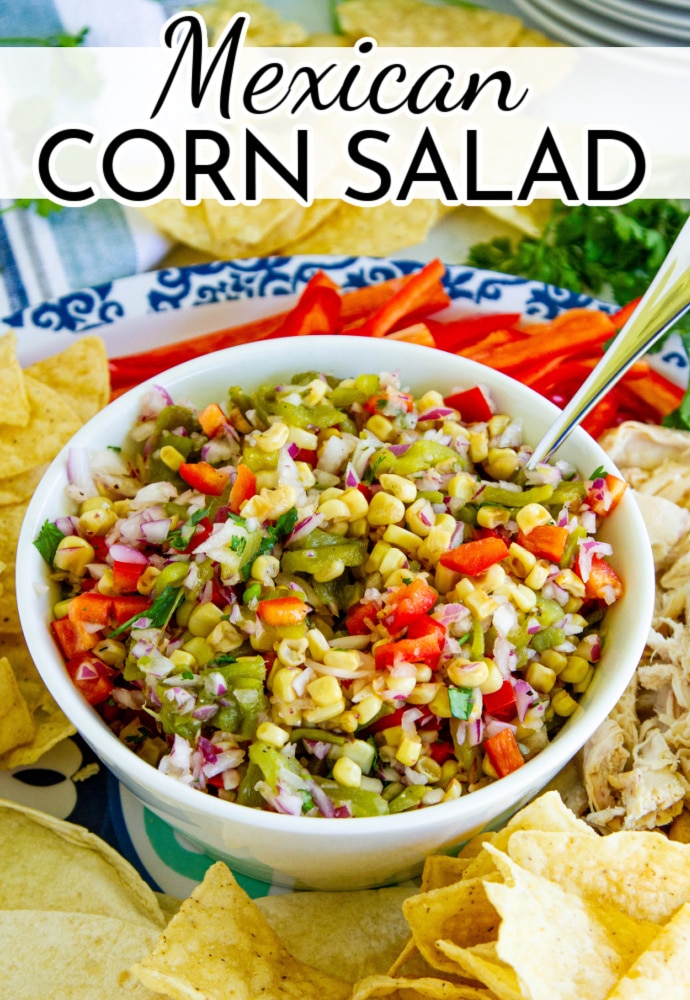 white bowl with colorful corn salad and plate of chips; text label reads: Mexican Corn Salad