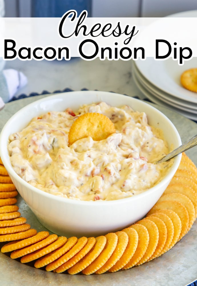 Platter of crackers with white bowl filled with dip; text label reads Cheesy Bacon Onion Dip