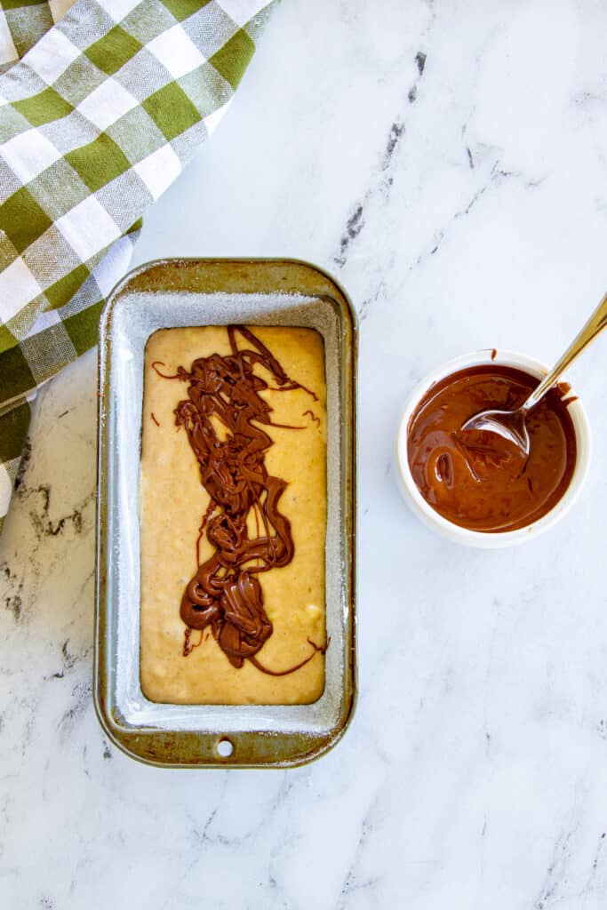 globs of nutella on top of batter in loaf pan