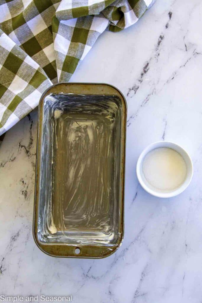 buttered loaf pan with sugar for coating