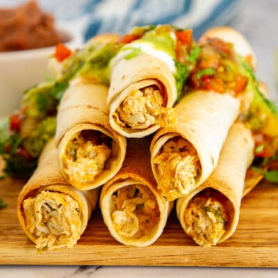 closeup of taquitos with chicken and cheese coming out the ends