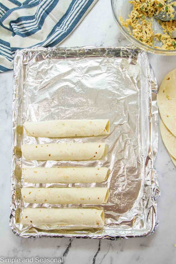 stuffed tortillas lying seam side down on a pan