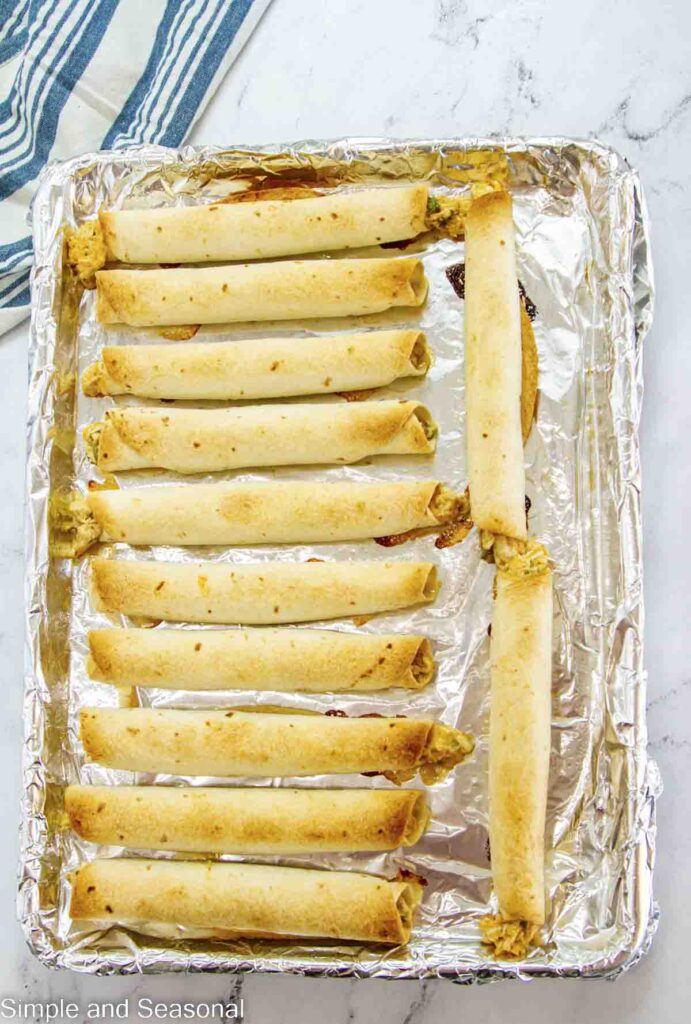 baked taquitos on a foil lined sheet pan