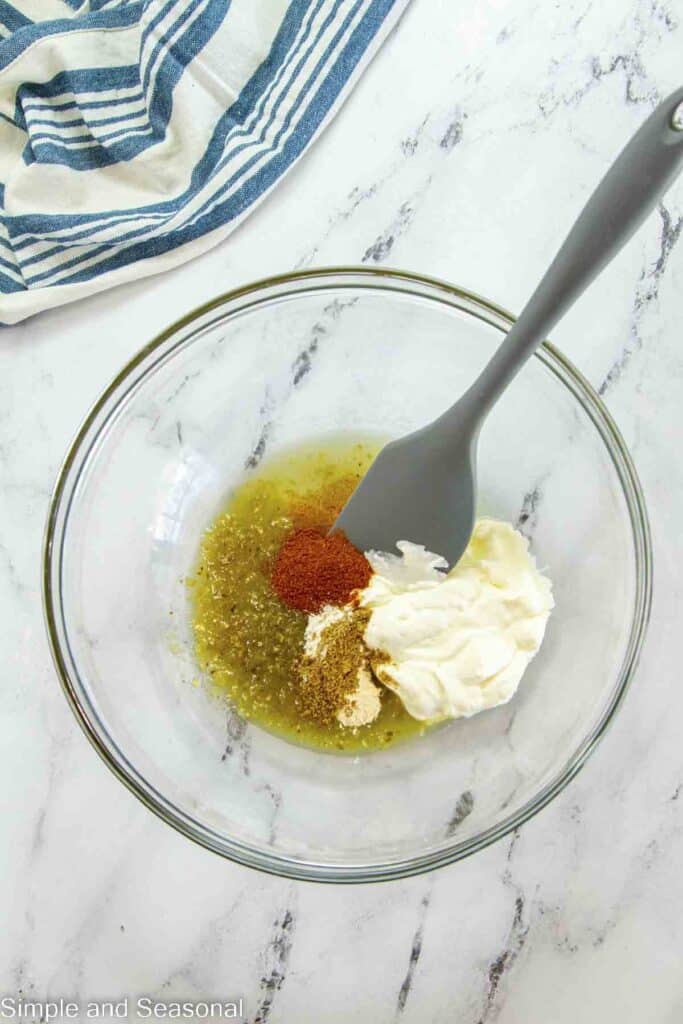 green salsa, cream cheese and seasonings in a bowl