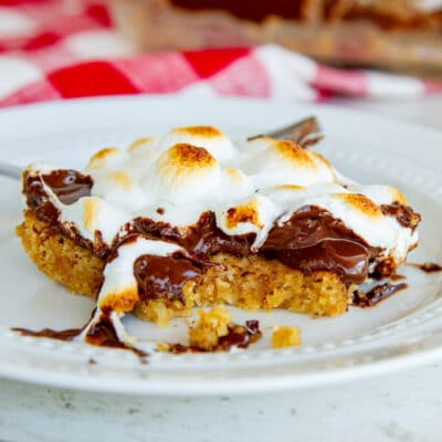closeup of cookie bar showing layers of cookie, melted chocolate and marshmallow
