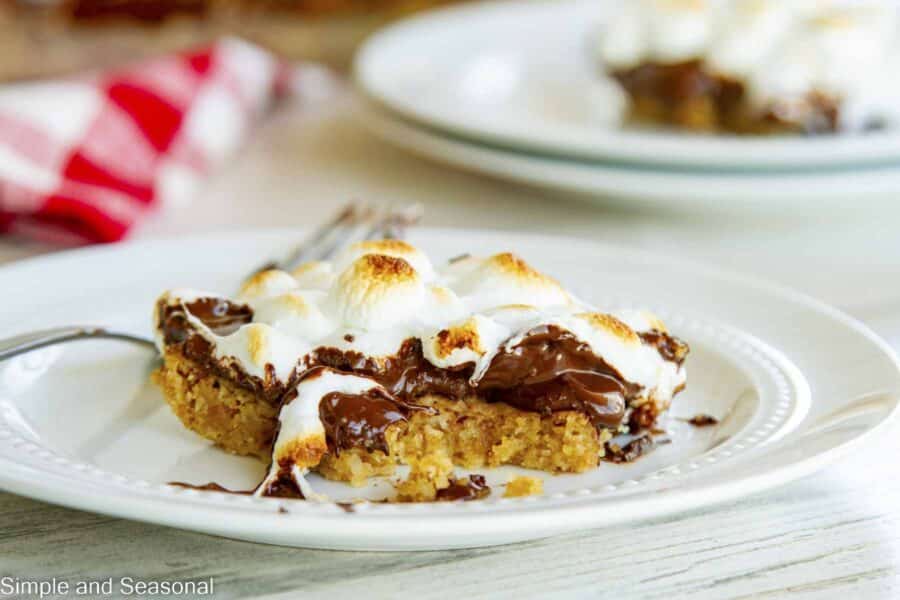 cookie bar on a plate with a fork and gooey chocolate oozing down
