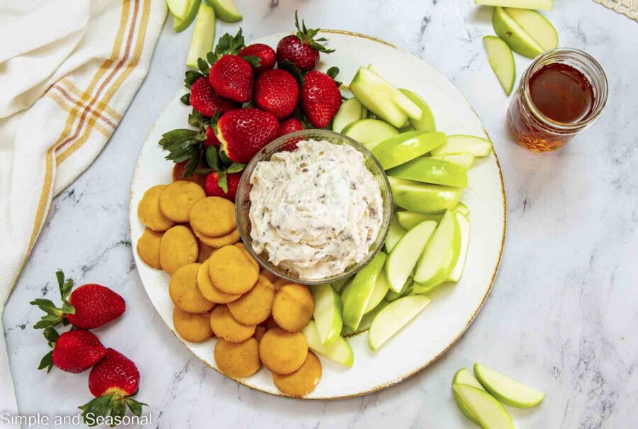 top down view of bowl of toffee dip with strawberries, apples and cookies for dipping