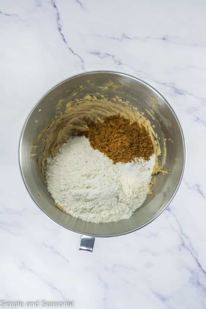 Flour and cookie crumbles in the mixing bowl with creamed batter