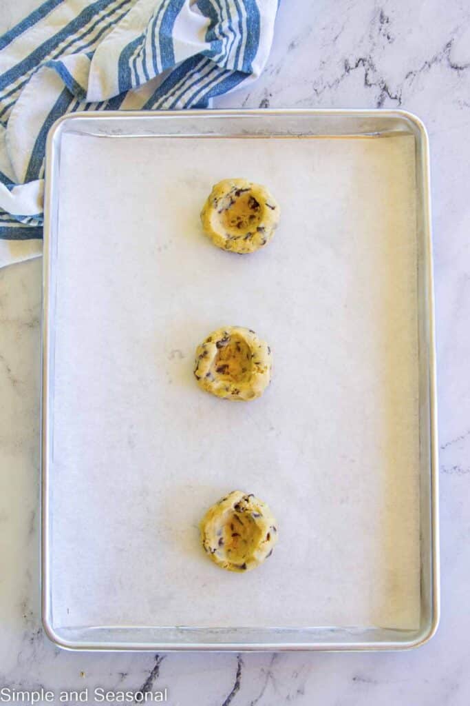 cookie dough with wells pressed into the middle for stuffing with chocolate