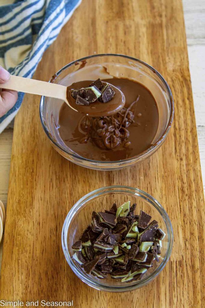 chunks of Andes mints on melted milk chocolate at the end of a spoon