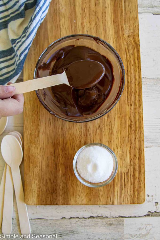 dark chocolate melted on a spoon with sea salt in the background