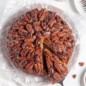 top down view of cake covered in pecan halves with slice being pulled out