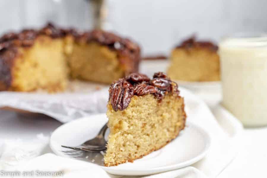 slice of pecan cake on a plate with the platter in the background