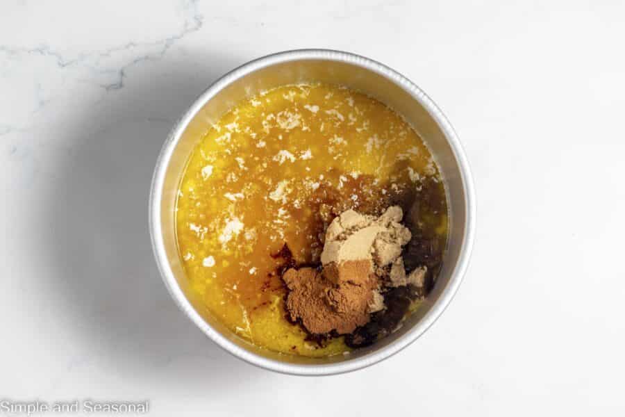 sugar, syrup and cinnamon added to melted butter in cake pan