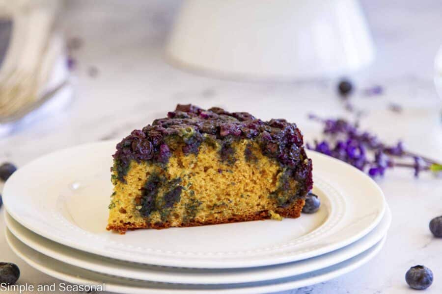 closeup on slice of blueberry upside down cake on a white plate