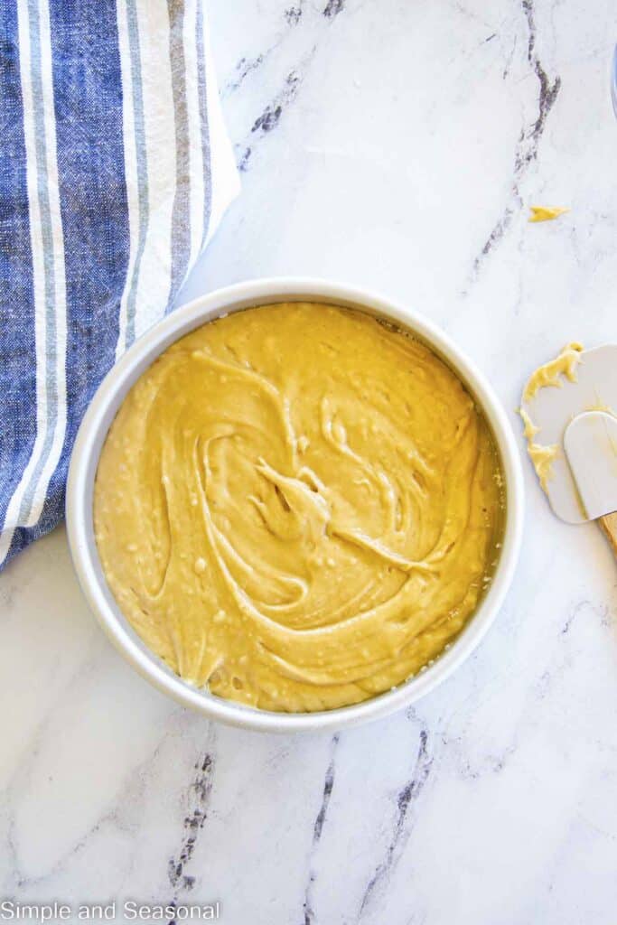 cake batter spread over the blueberry layer