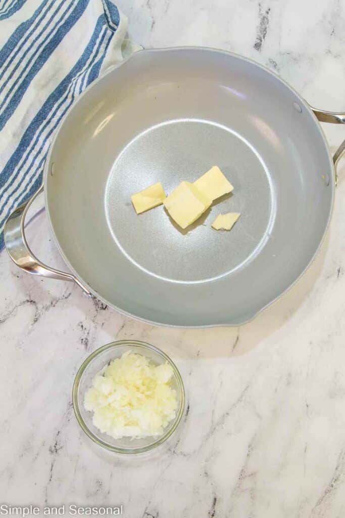 butter in a skillet with diced onions on the side