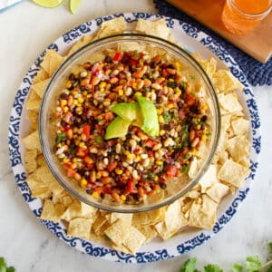 top down view of bowl of bean salad on a blue and white platter